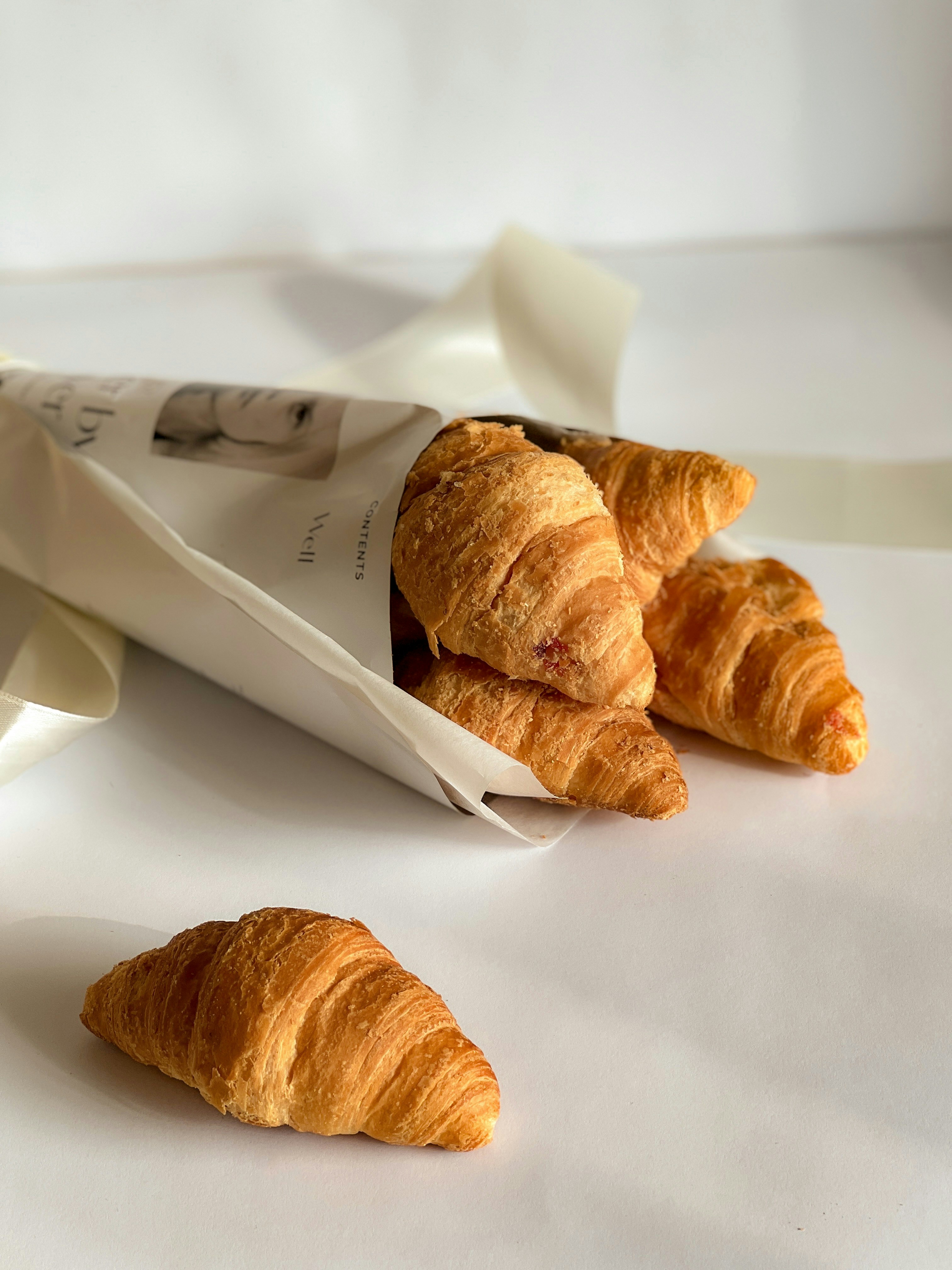 Several croissants spilling out of a paper cone.